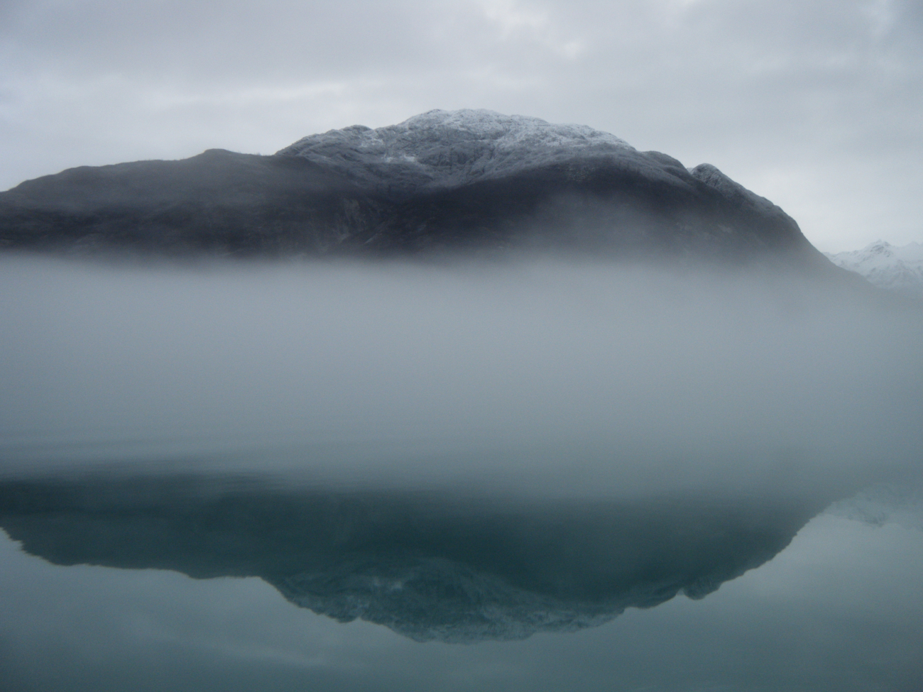 Mountain, a wisp of fog, and reflection in Glacier Bay
