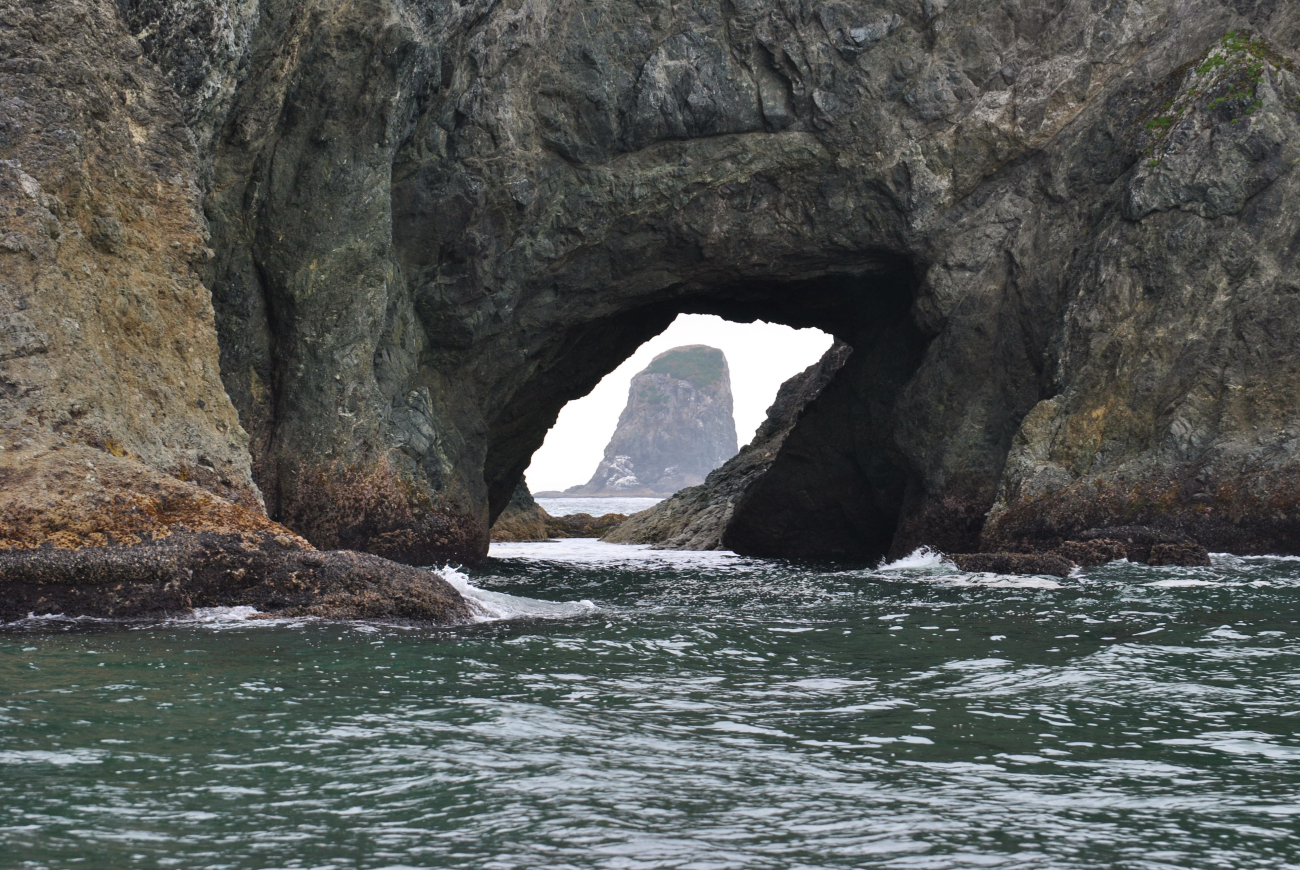 A view of a sea stack through an arch