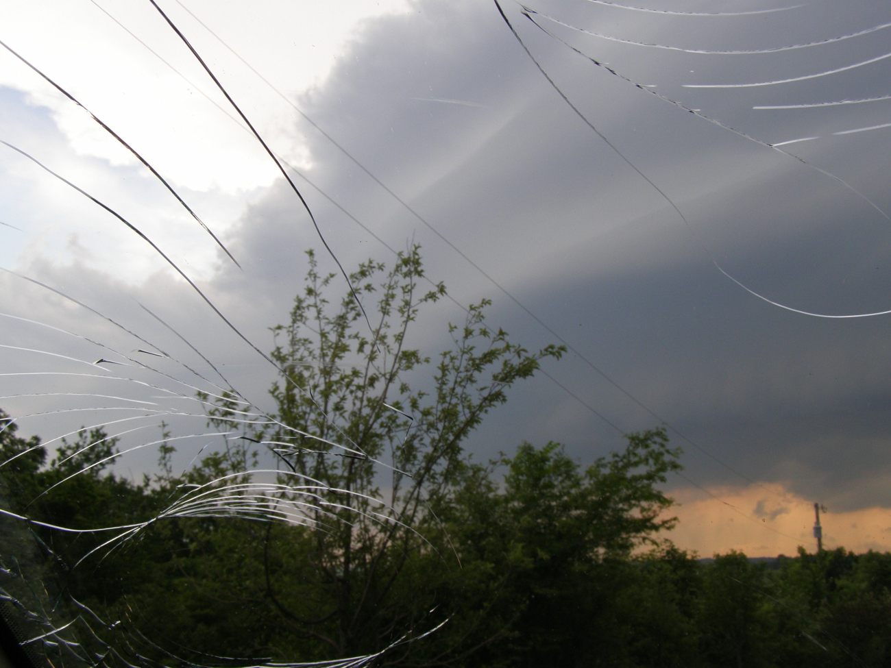 VORTEX2 tornado investigators peering through a windshield cracked by hail