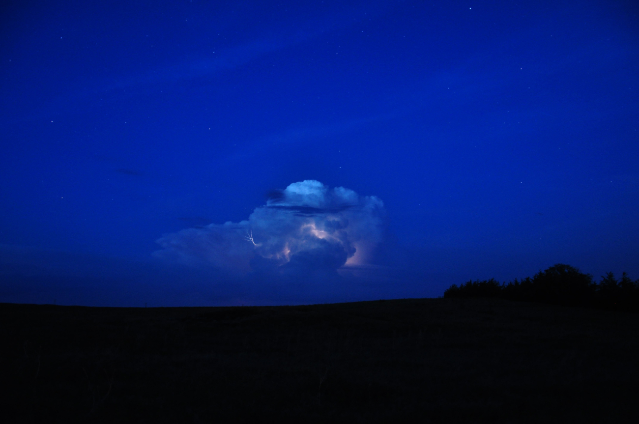 Supercell thunderstorm illuminated by lightning at night
