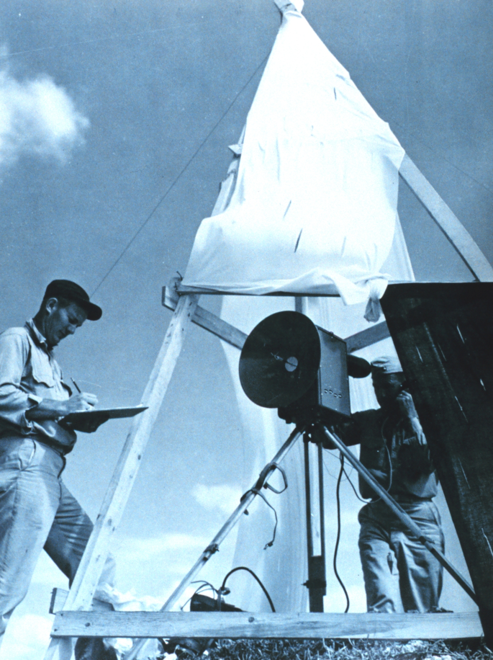 Charles Kearse, Chief Electronics Technician on the EXPLORER recordstellurometer distance measurements observed by Commander Ray Stone at SwanIsland in the Caribbean during C&GS; Ship EXPLORER expedition from West Coastbase to East Coast base in January - April 1960
