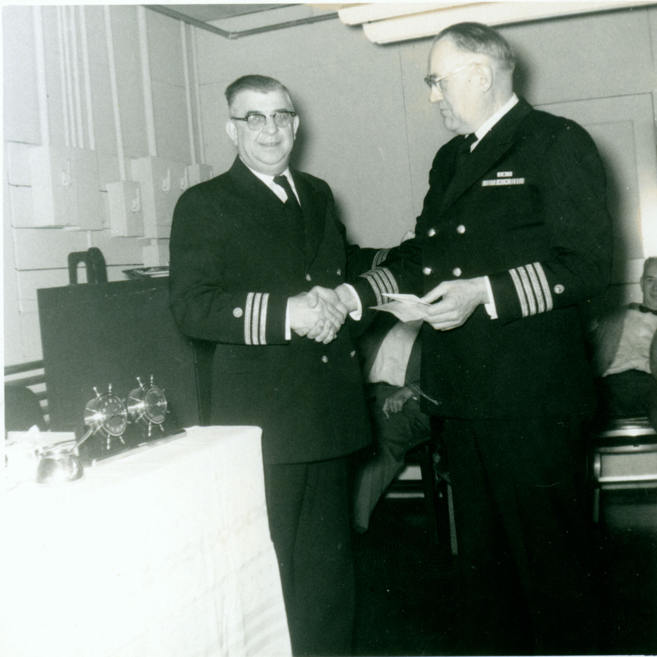 Commander Carl Mast on left congratulating Captain Albert Hoskinson on right onthe occasion of his retirement