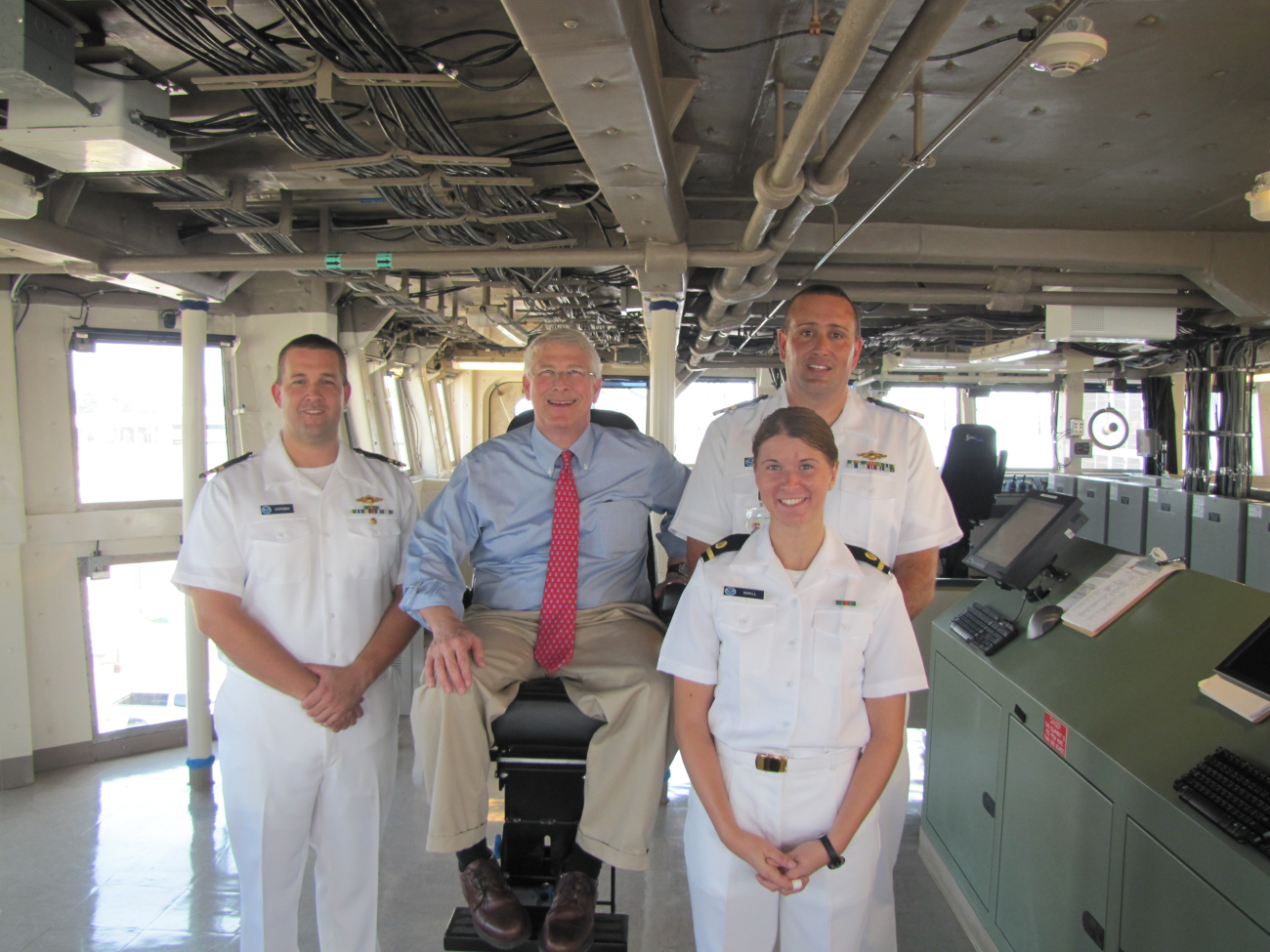 Commander Jeremy Adams, commanding officer of NOAA Ship PISCES atright rear, Ensign Schill, right front, Lieutenant CommanderChrobak, Executive officer, and Fisheries official in captain's chair of NOAAShip PISCES