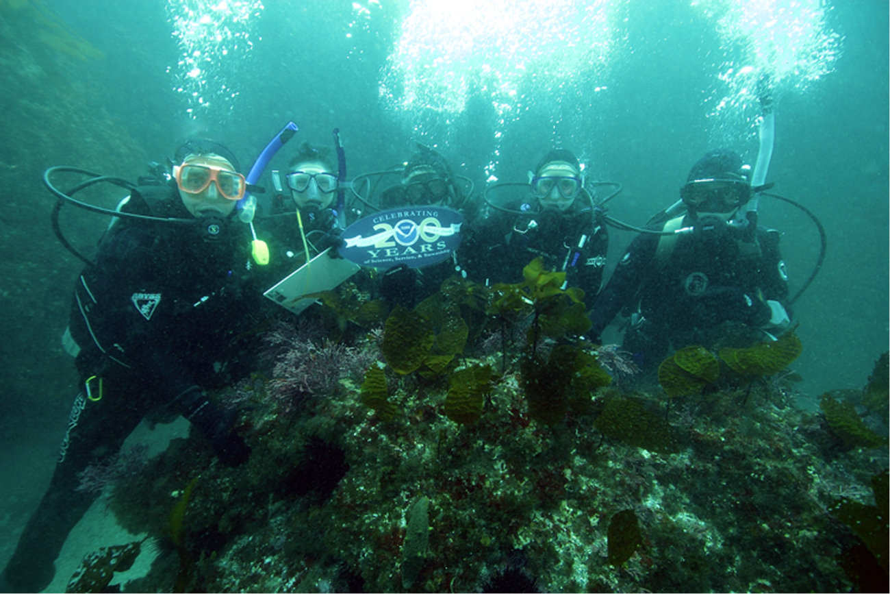 Channel Islands National Marine Sanctuary dive team members are displaying theNOAA 200th banner during a REEF fish survey in the waters off Anacapa Island