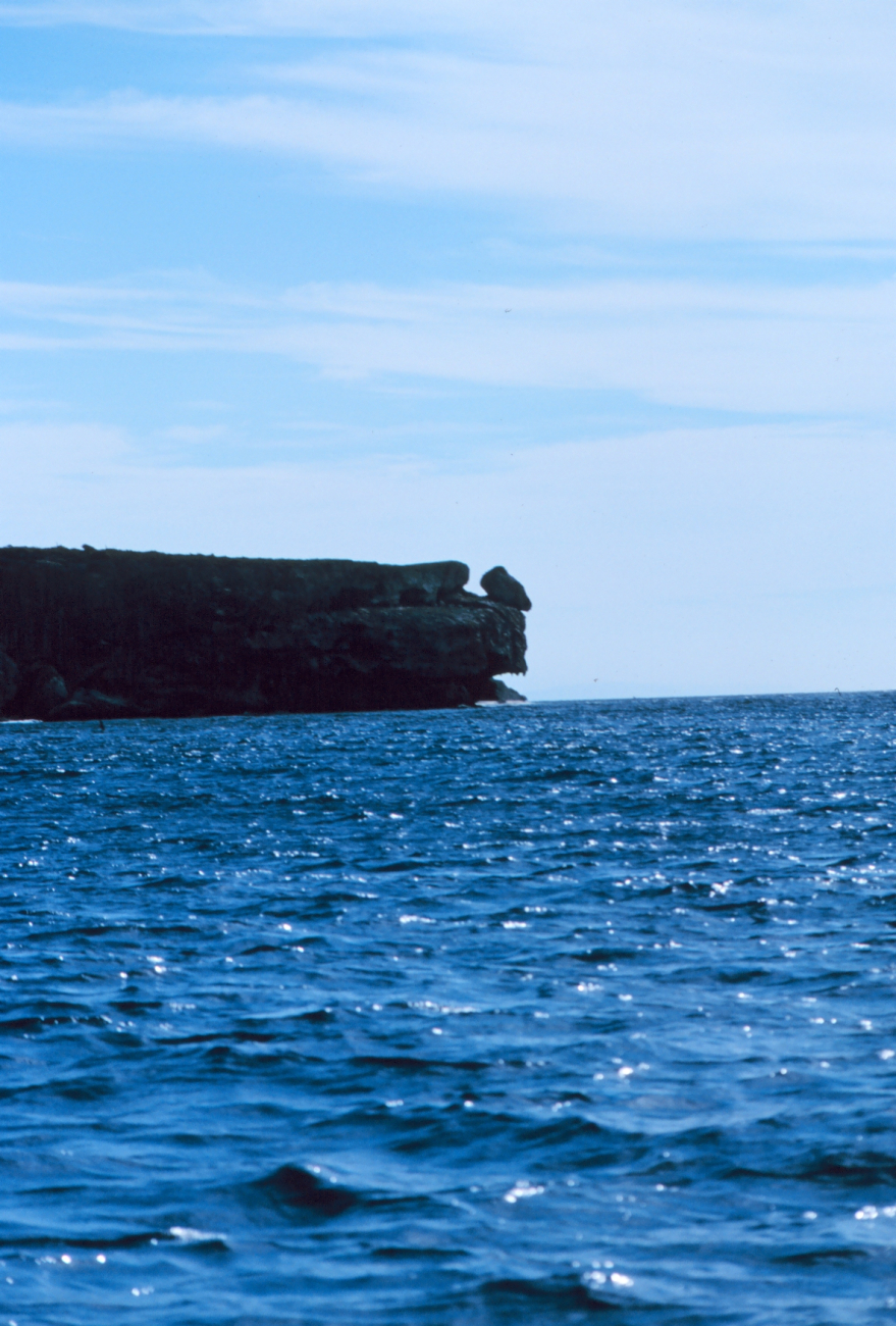From the water, a prominent cliff face of Mona Island