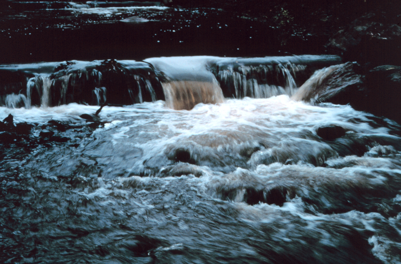 Water rushes over the lip of the pools