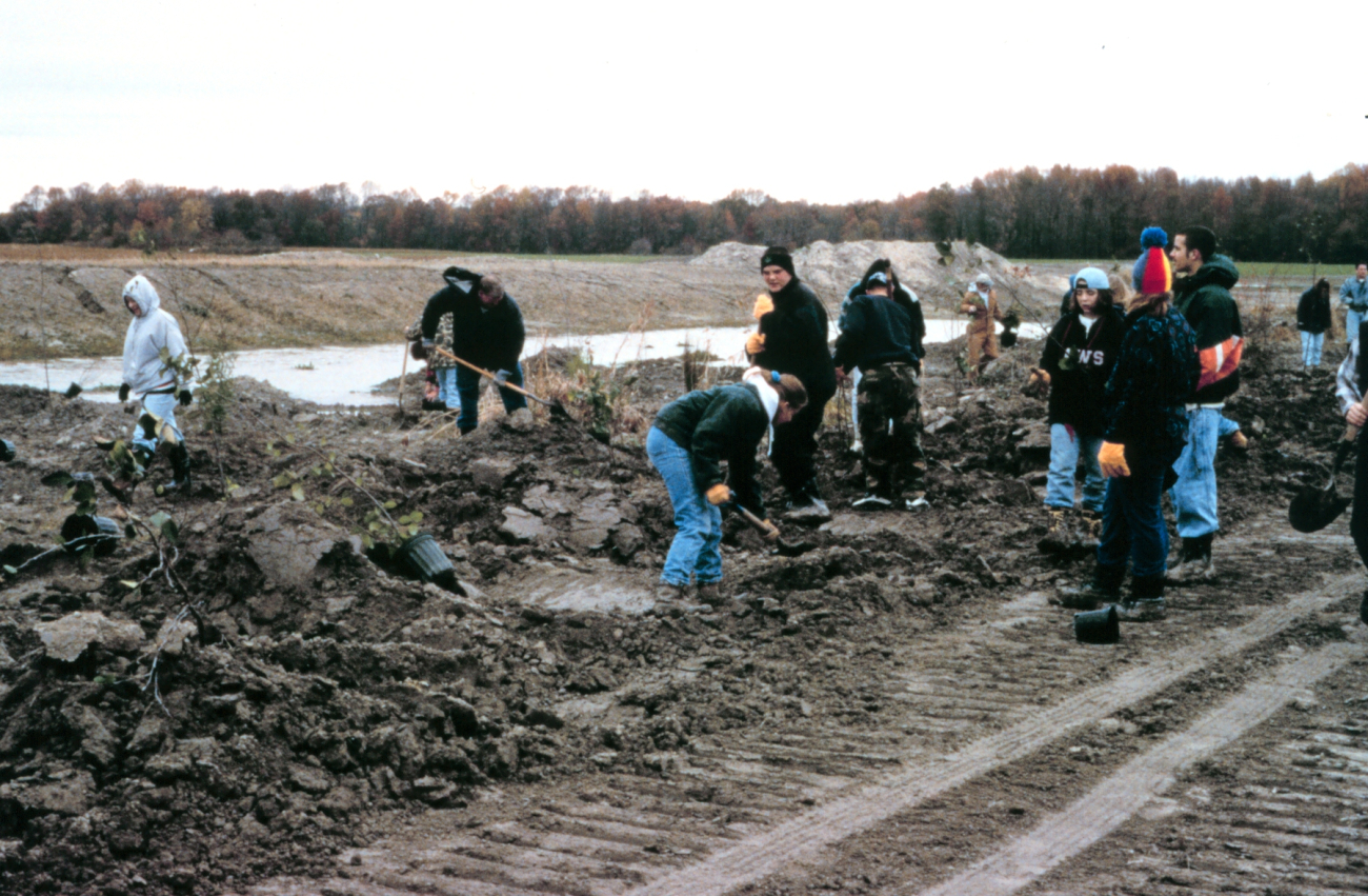 A group of students plant along the flood plain
