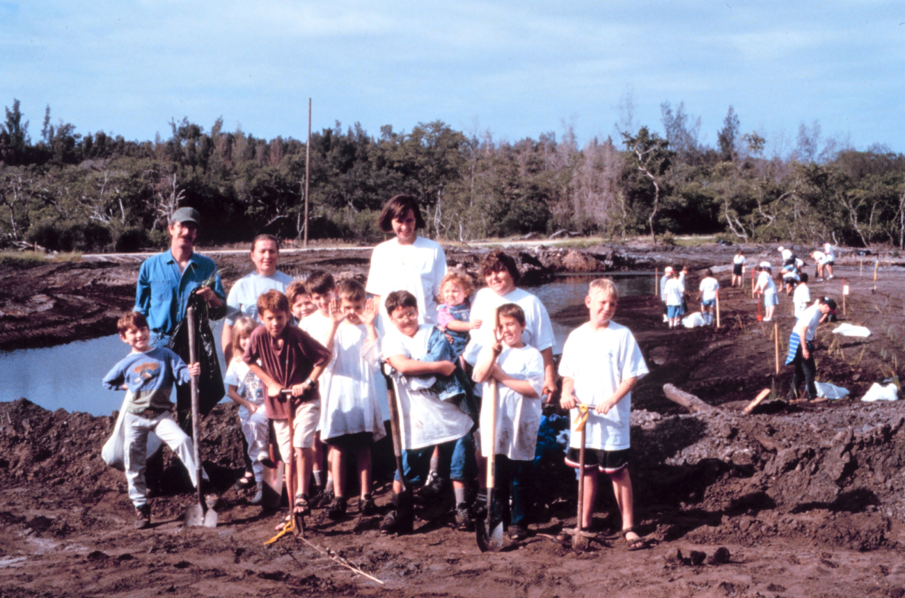 A group of boy scouts and their leaders plant native wetland plantsin Palmetto, Manatee County, Florida