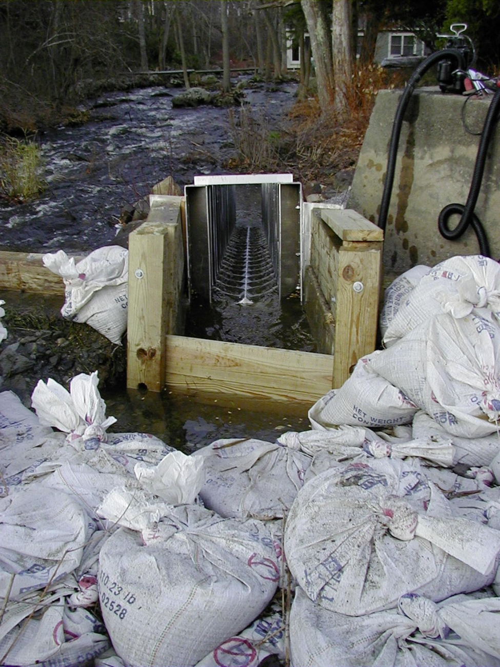 Sand bags hold back water flow while the fishway is installed