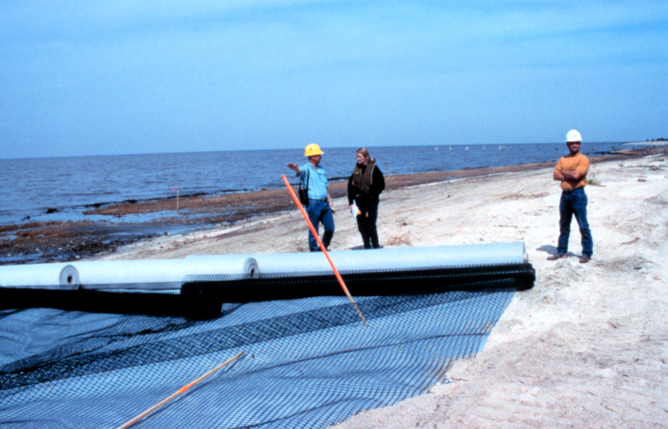 Brian Kendrick, Chris Gray and a Bertucci representative standing by roles offilter cloth and geogrid on the beach