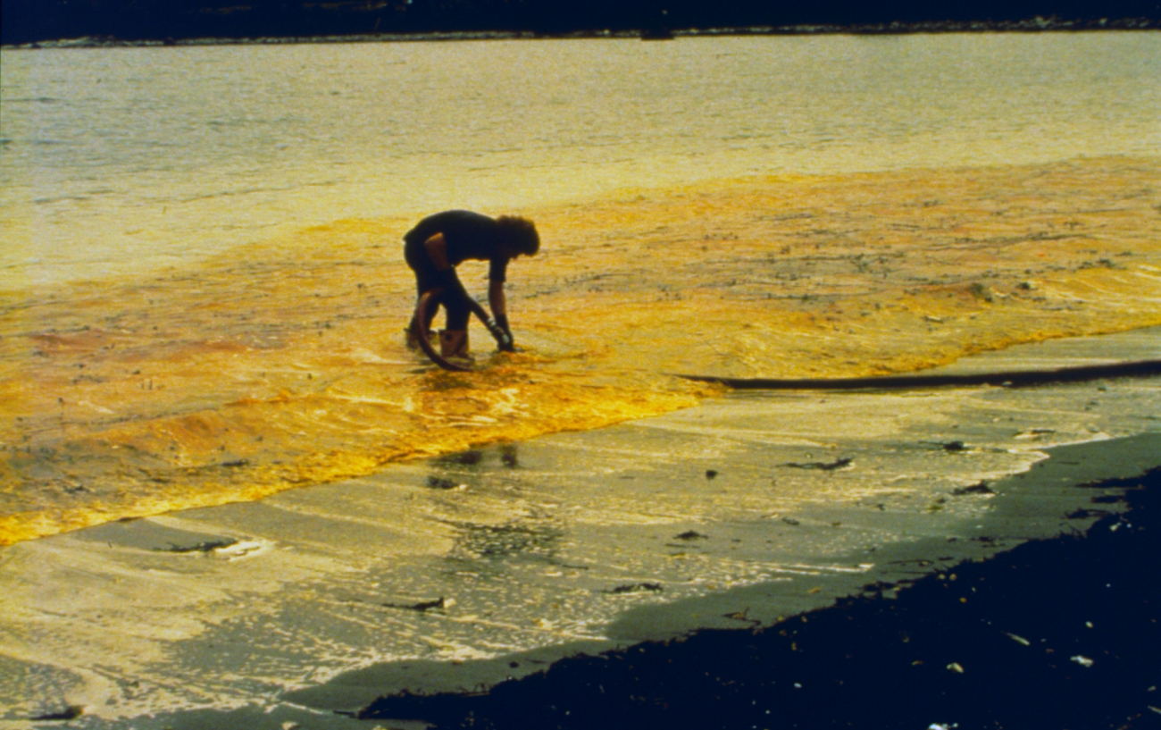 A clean-up worker in the process of skimming oil as part of the clean-upprocess after the World Prodigy oil-spill