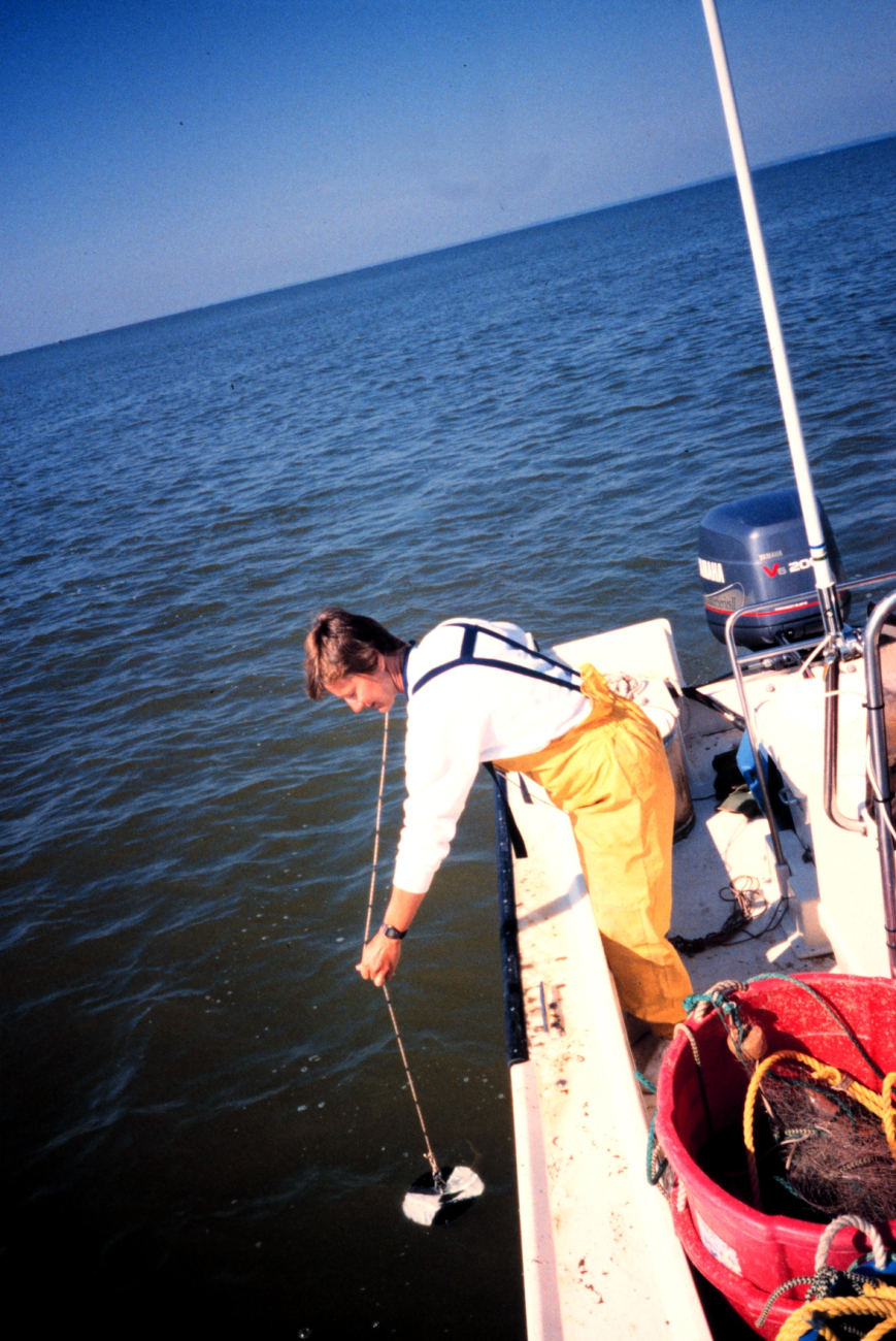 A former NOAA staff member takes a secchi depth reading