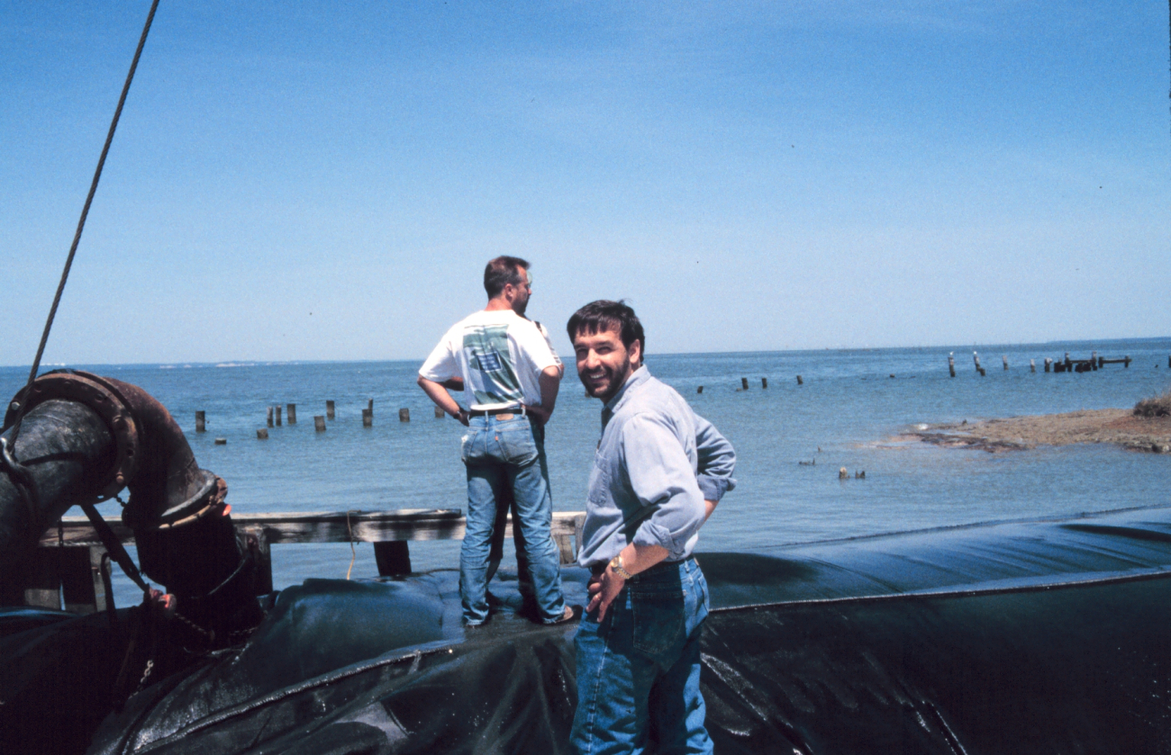 Lee Crockett, formerly of NOAA, stands in front of a geotube being filled