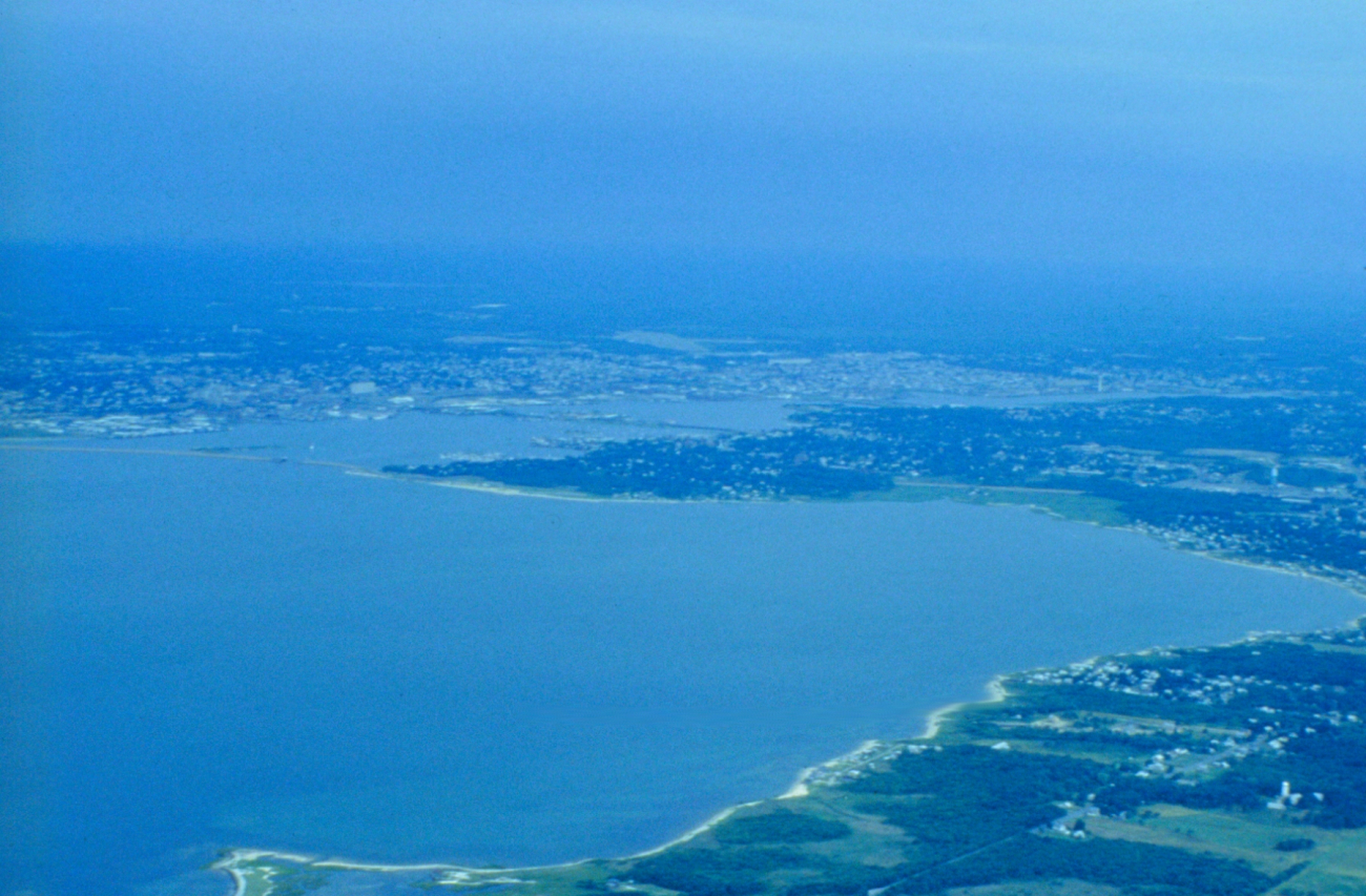 A distant view of Fairhaven and New Bedford Harbor with Sconicut Neck on theright
