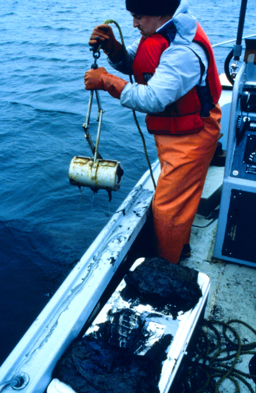 Point Judith Pond, RI DEM worker retrieves a lobster pot used to samplelobsters and determine their exposure to oil
