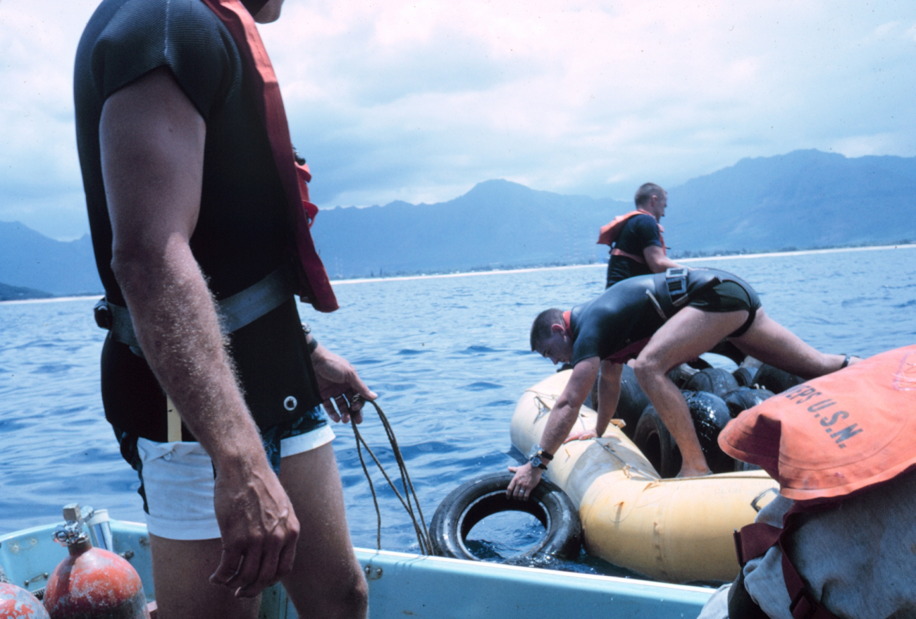 Navy divers assisting in the placement of used tires as an alternate reefmaterial on the artificial reef site at Pokai Bay, Oahu