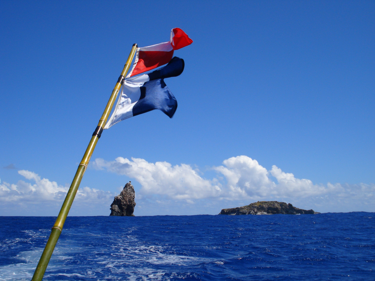 Flags denoting divers down with the islets of Motu Iti and Motu Nui in thebackground