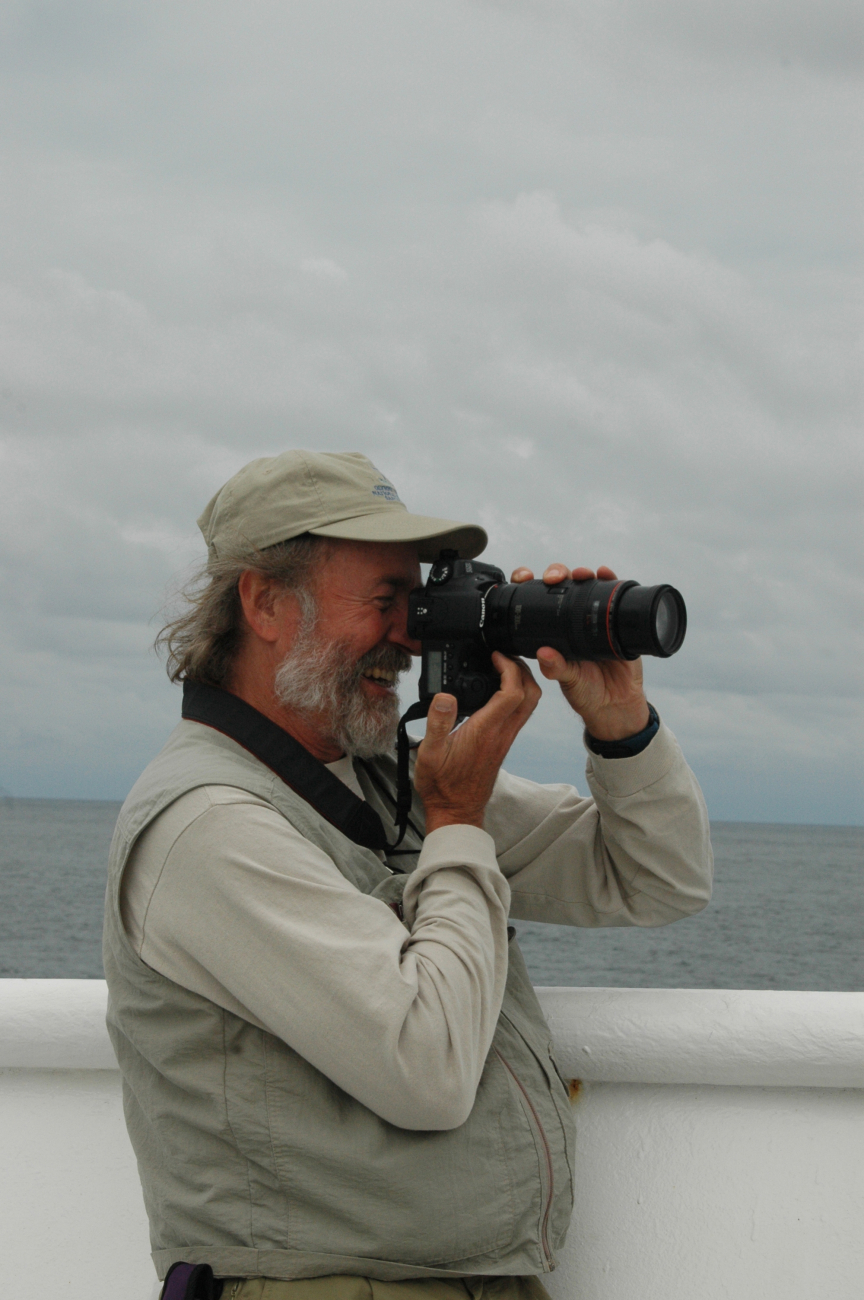 Ed Bowlby, Research Coordinator for the Olympic Coast National MarineSanctuary, photographing humpback whales feeding just off the bow of theNOAA Ship McARTHUR II