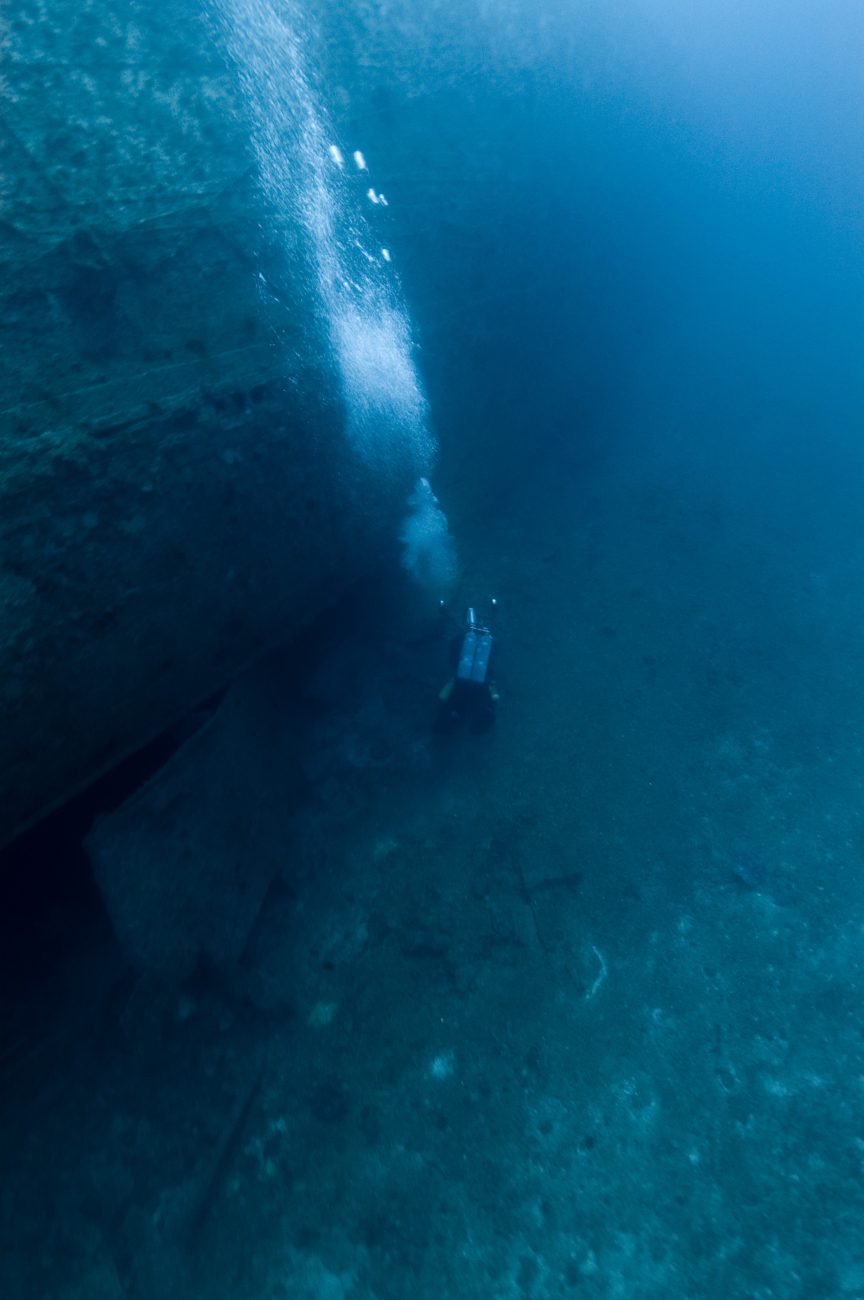 Diver below stern and upside-down rudder of the NORTHERN LIGHT, a shipwreck in190 feet water depth
