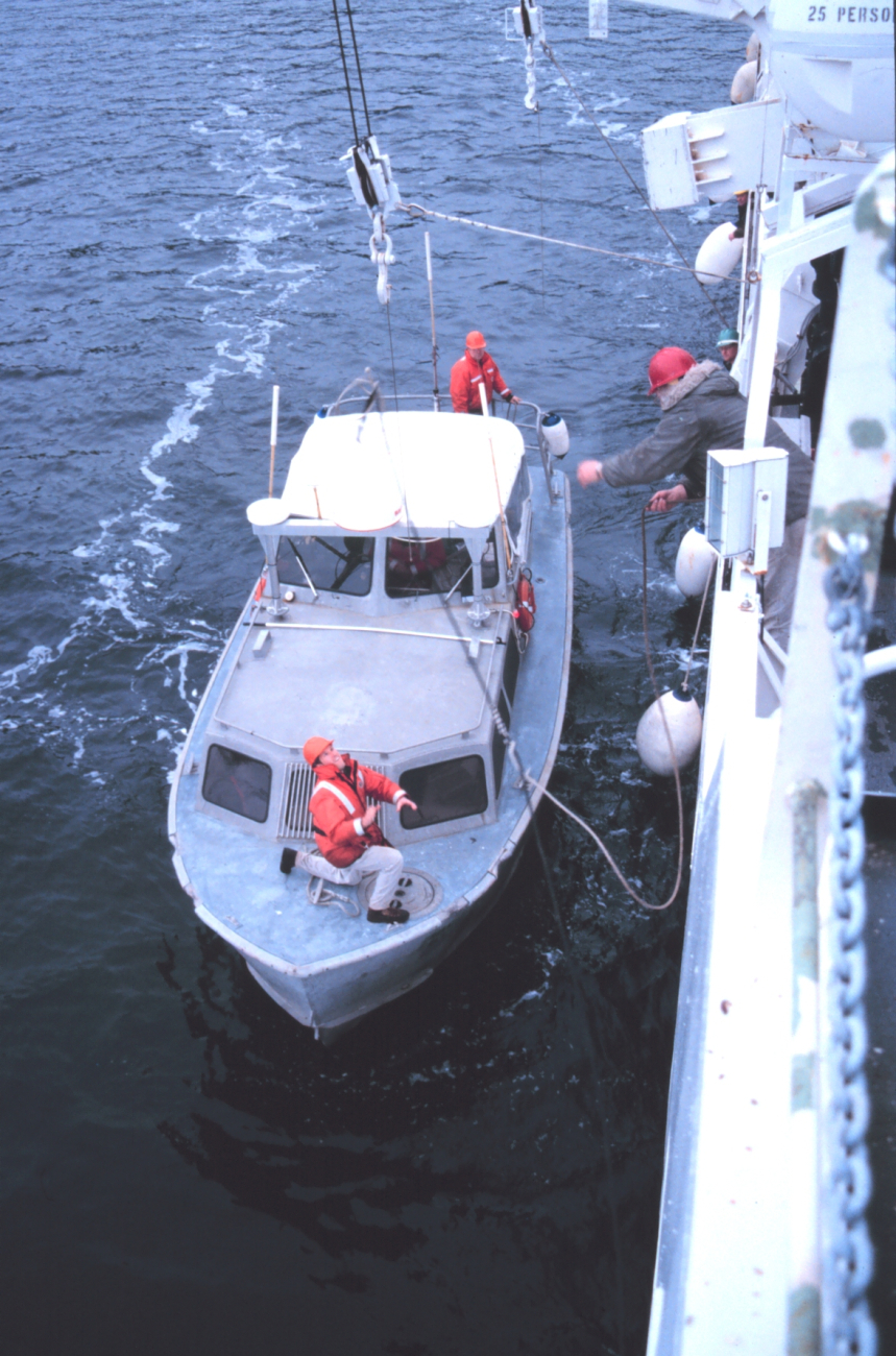 Seaman Surveyor Geno Gallinati tosses a leader-line to Senior Survey Tech PaulMcAnally in preparation for hoisting RA-1 boat