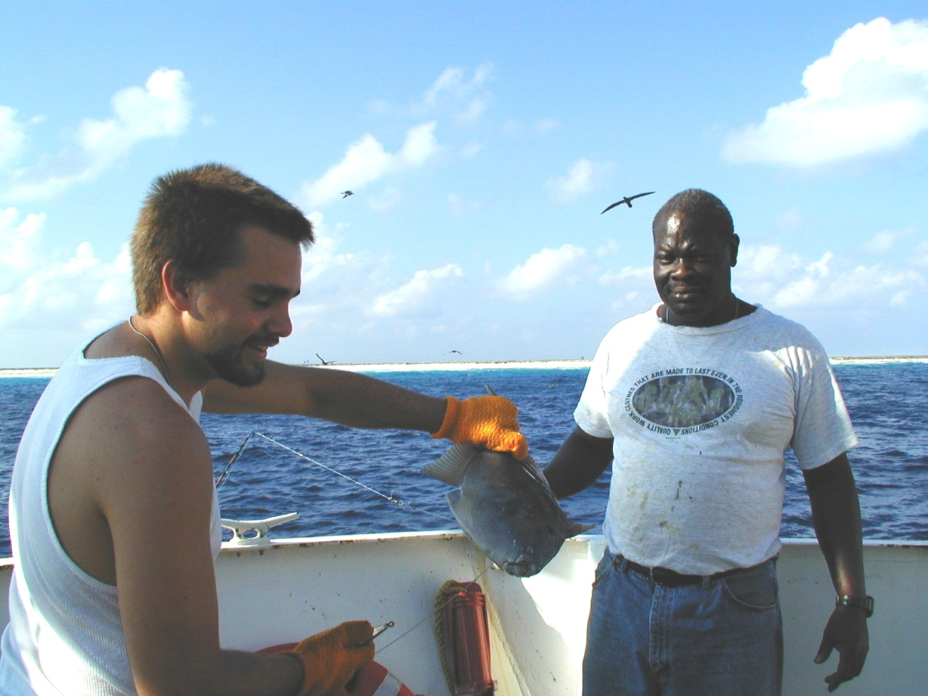 Deck hand Mike Theberge and seaman surveyor Leroy Johnson with fishcaught off Clipperton Island during STAR 2000