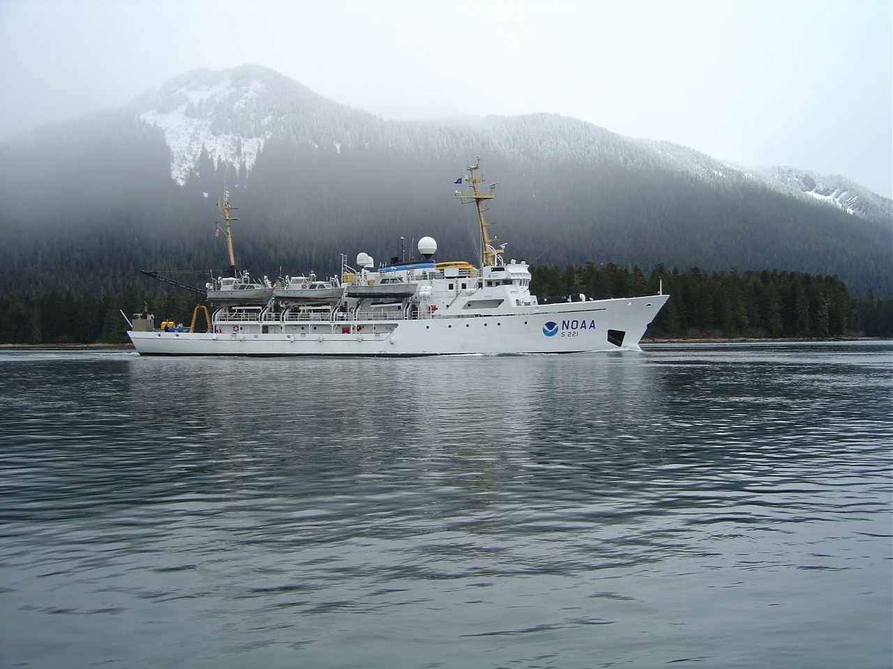 NOAA Ship RAINIER underway in Alaskan waters with snow-dusted mountains asbackdrop