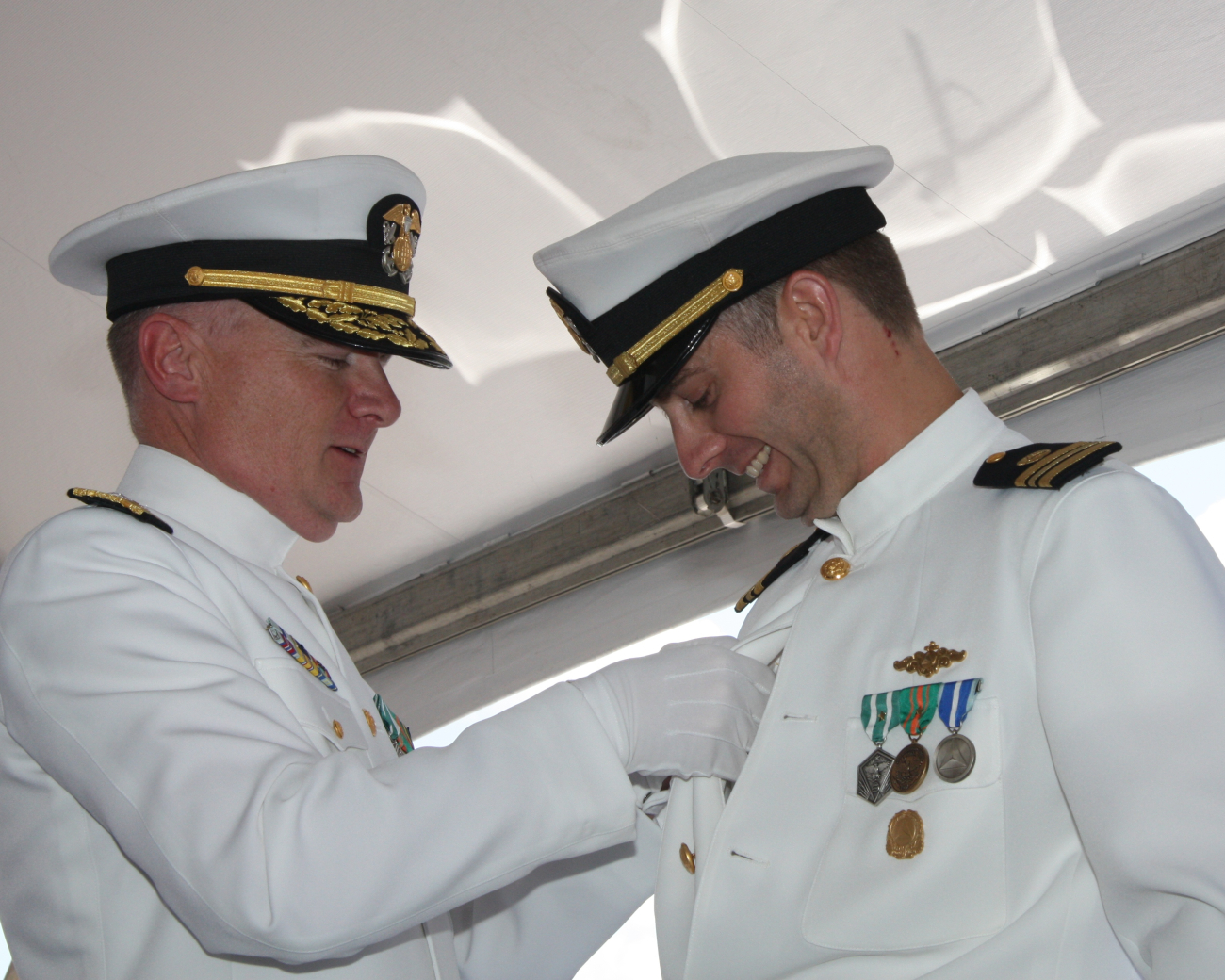 Rear Admiral Michael Devany pins the command at sea pin on LieutenantCommander Ben Evans, the brand-new commanding officer of the justcommissioned NOAA Ship FERDINAND R