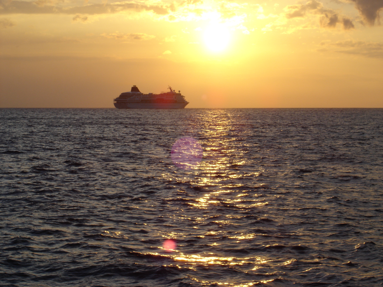 A cruise ship sailing into the sunset