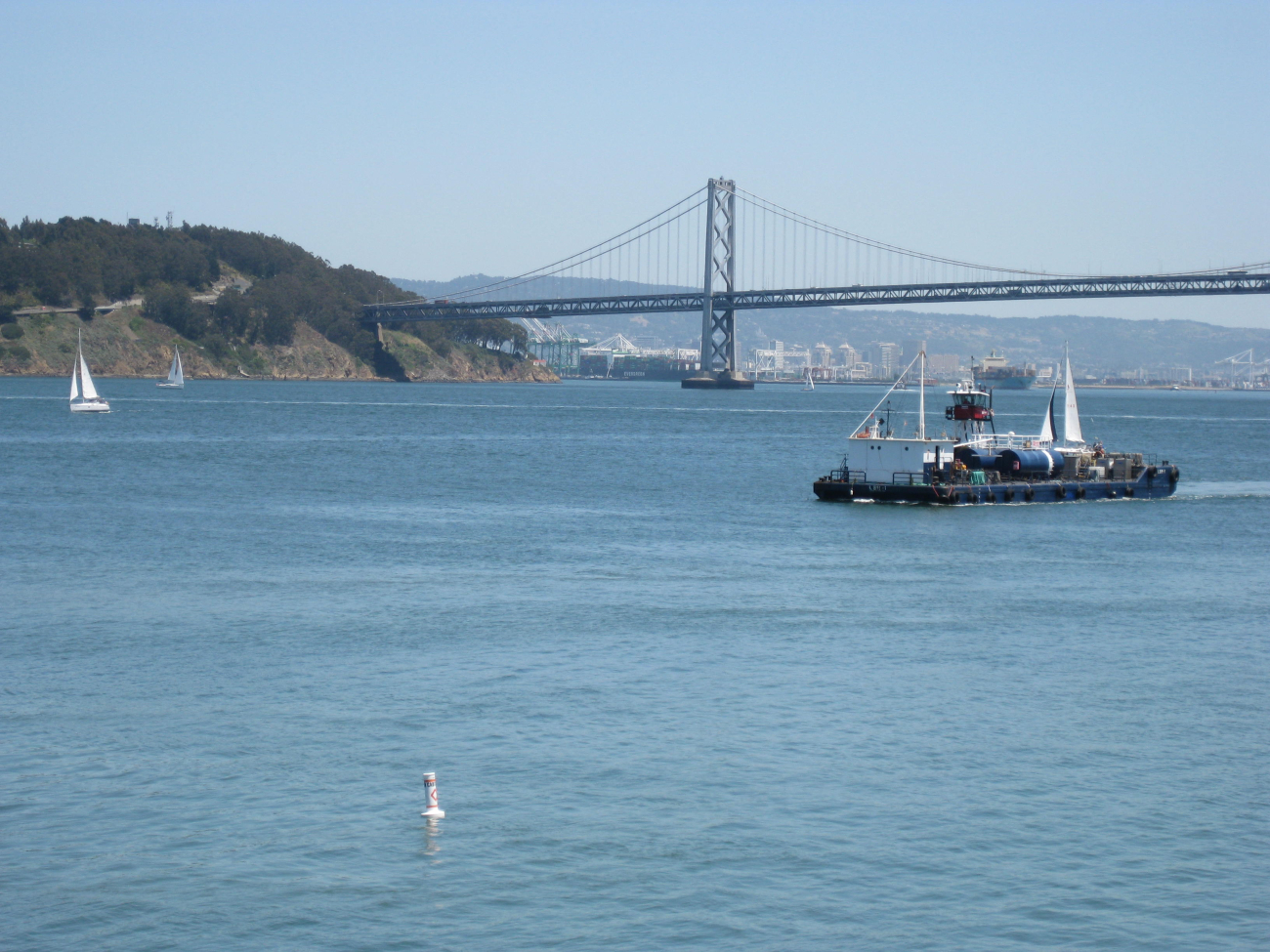 A self-propelled barge plying the waters of San Francisco Bay having just sailedunder the Bay Bridge headed north