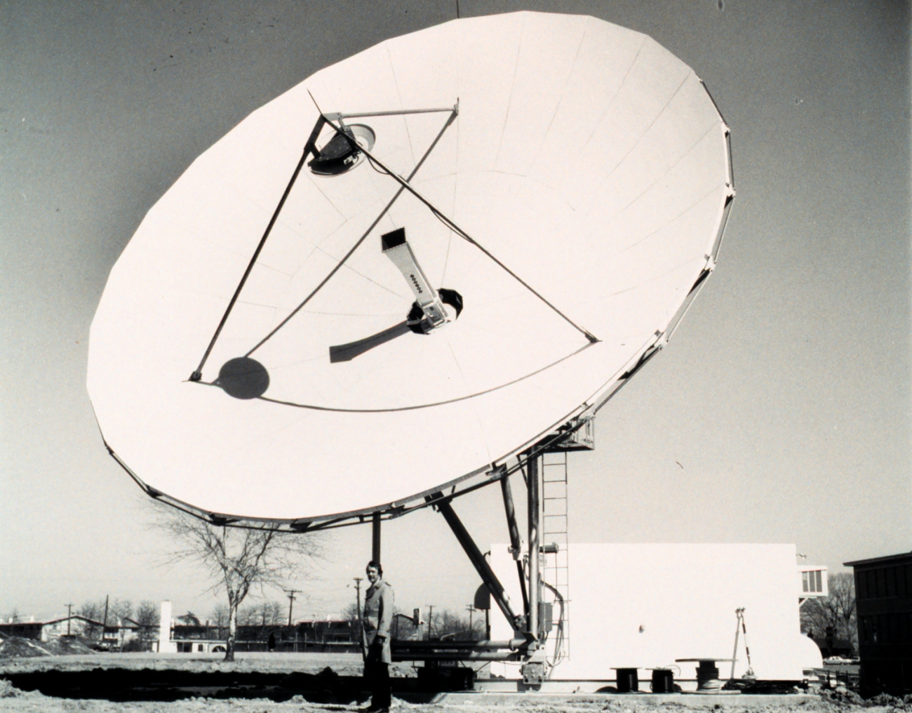 John Hussey, TIROS-N Ground System Project Manager, standing below 36-ft(11-meter) antenna