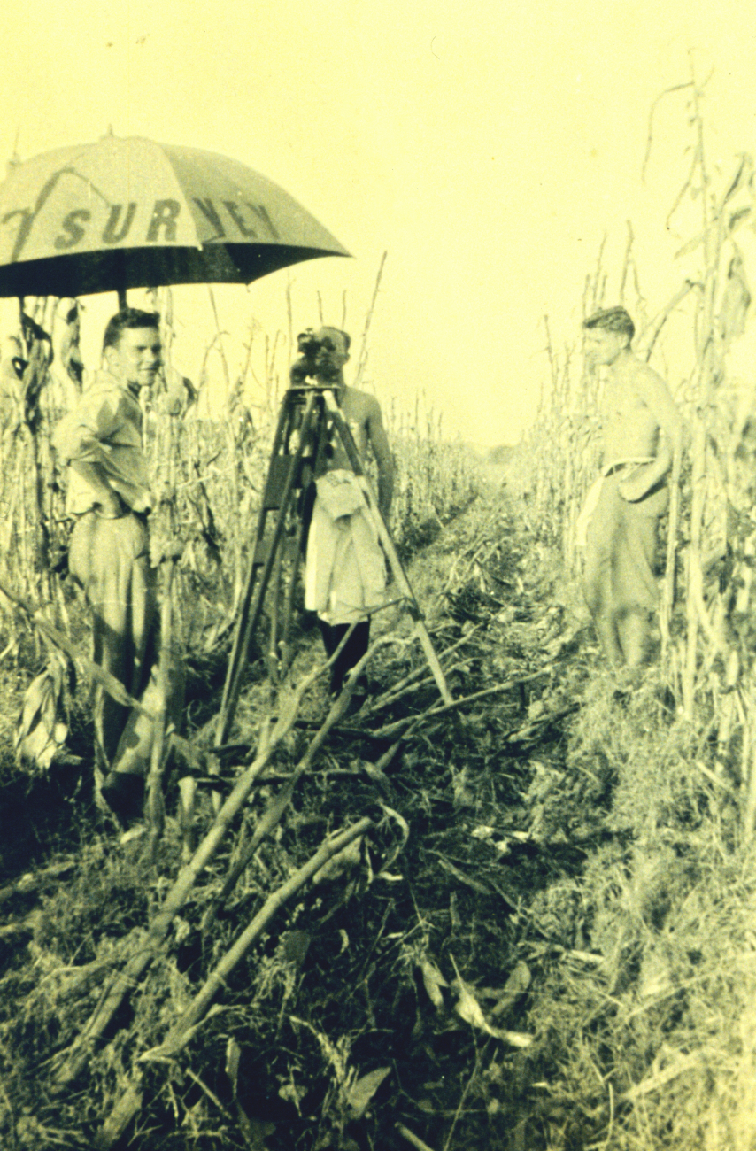 George Hastings observing levels; Smitty Smith holding umbrella; and BillUnger (?) gun-toter