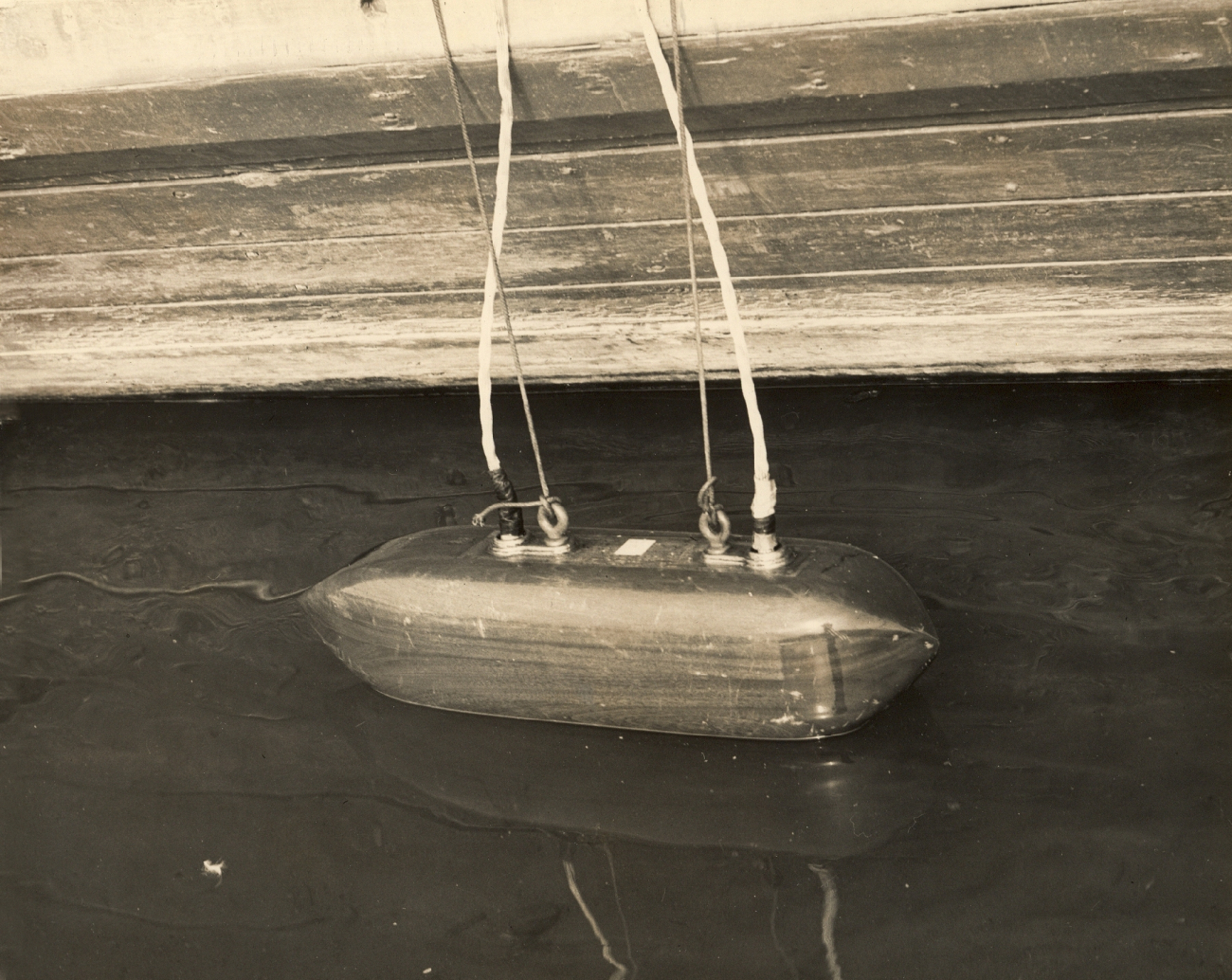 Portable fathometer transducer being lowered into water