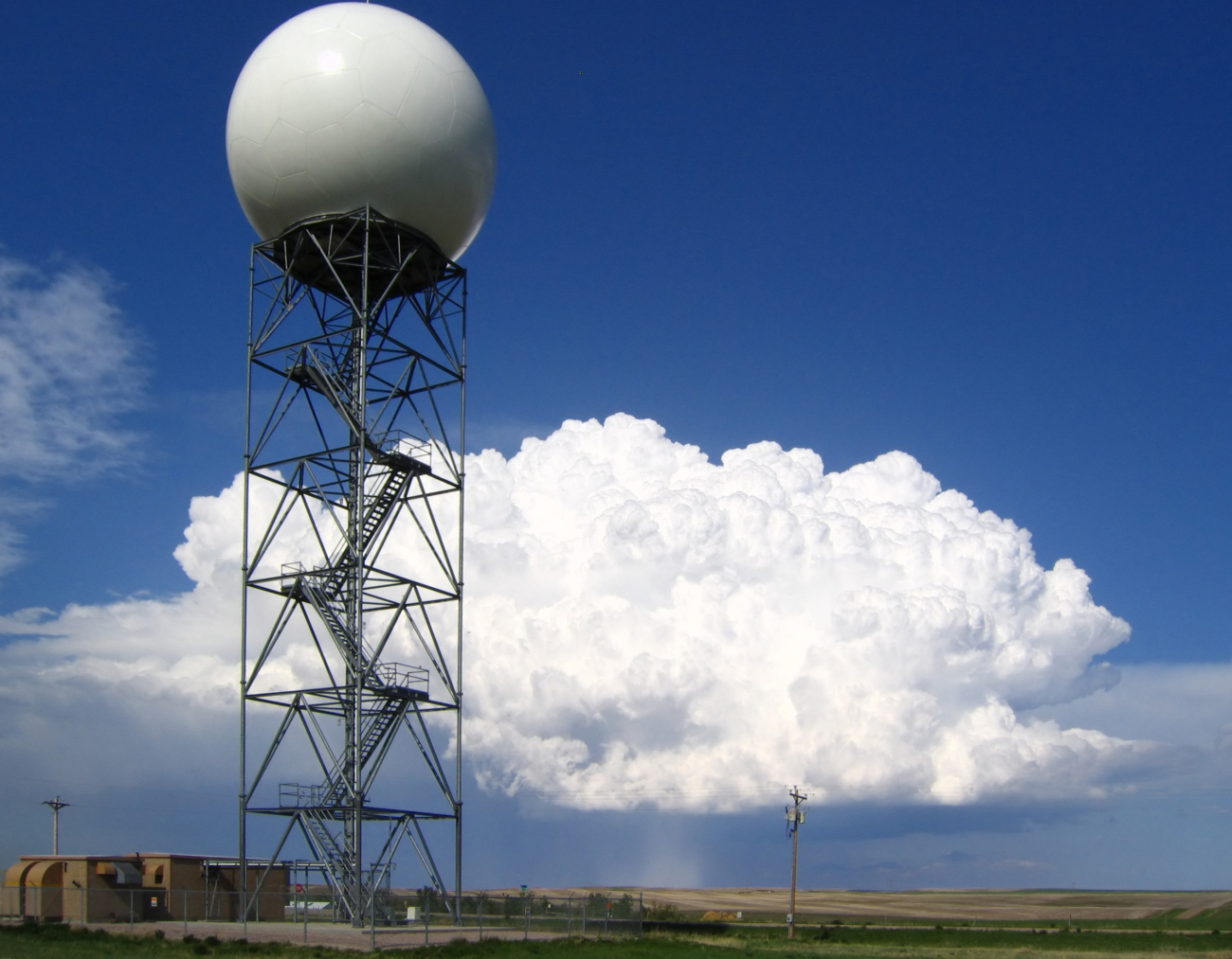 A strong supercell thunderstorm drops hail, with the WSR-88D Doppler radarat New Underwood, SD in the foreground