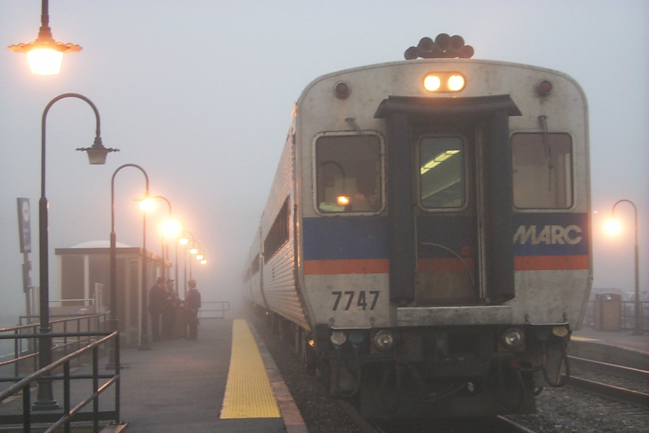 MARC commuter train conductor catching up with local news on a foggy morning at Brunswick, MD