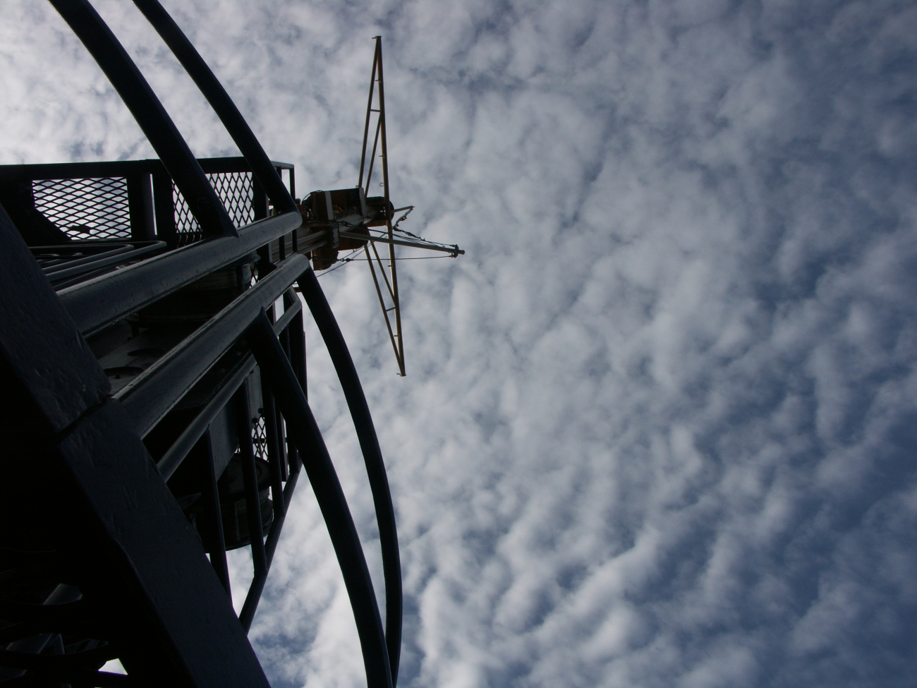 FAIRWEATHER's mast silhouetted against a cloudy sky