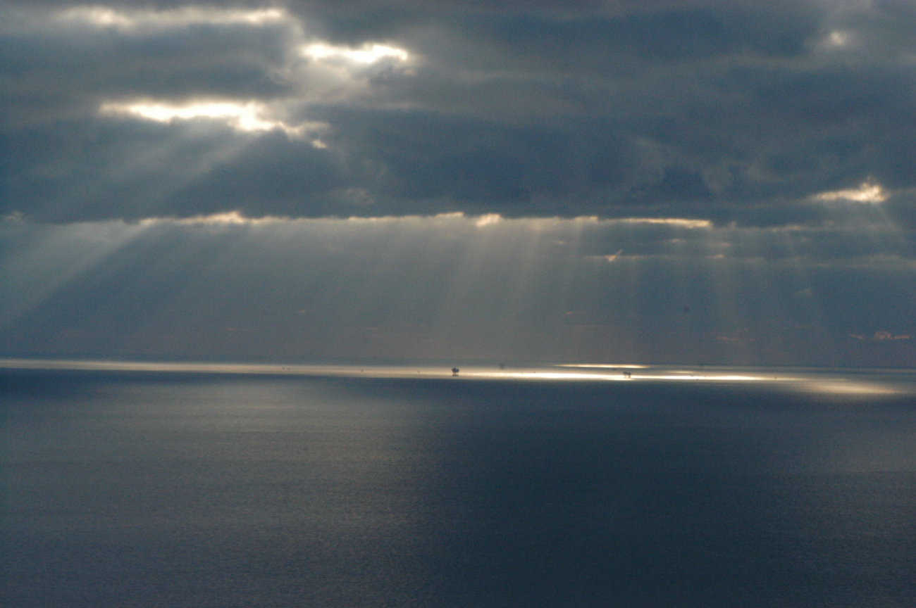 Crepuscular rays illuminate oil platforms in the Gulf of Mexico