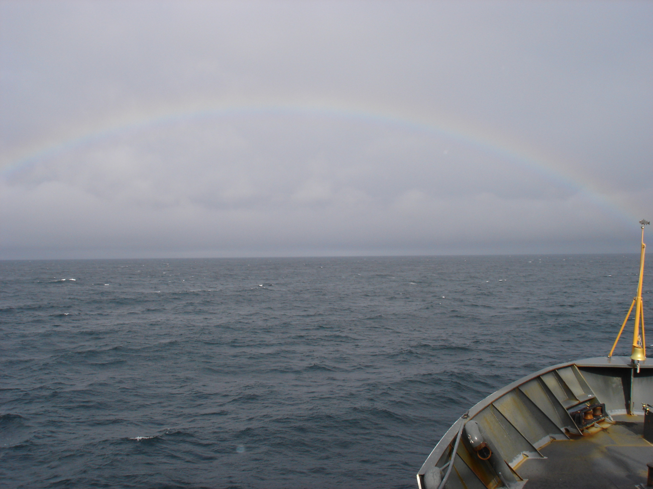 A full rainbow seen on a gray North Pacific day