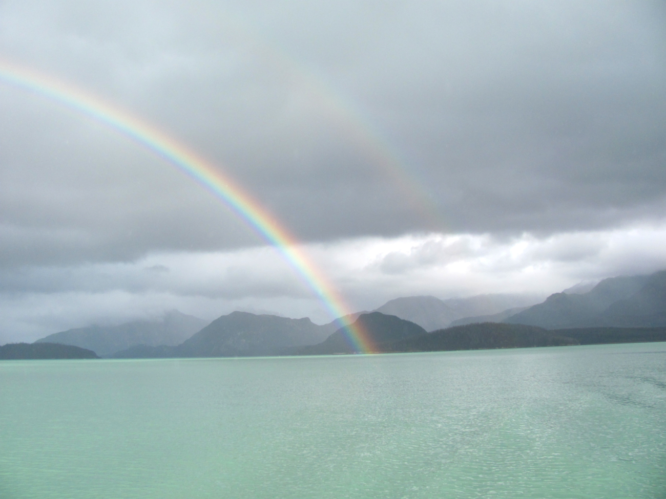 Double rainbow over milky green waters of Cross Sound