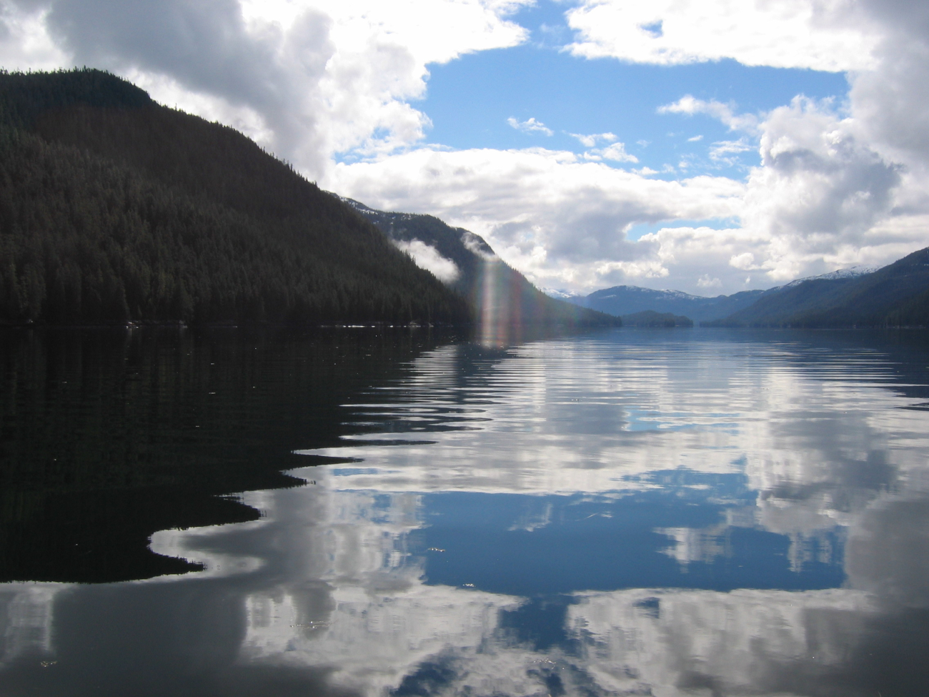 Cumulus clouds reflecting on the water of an Alaskan Bay