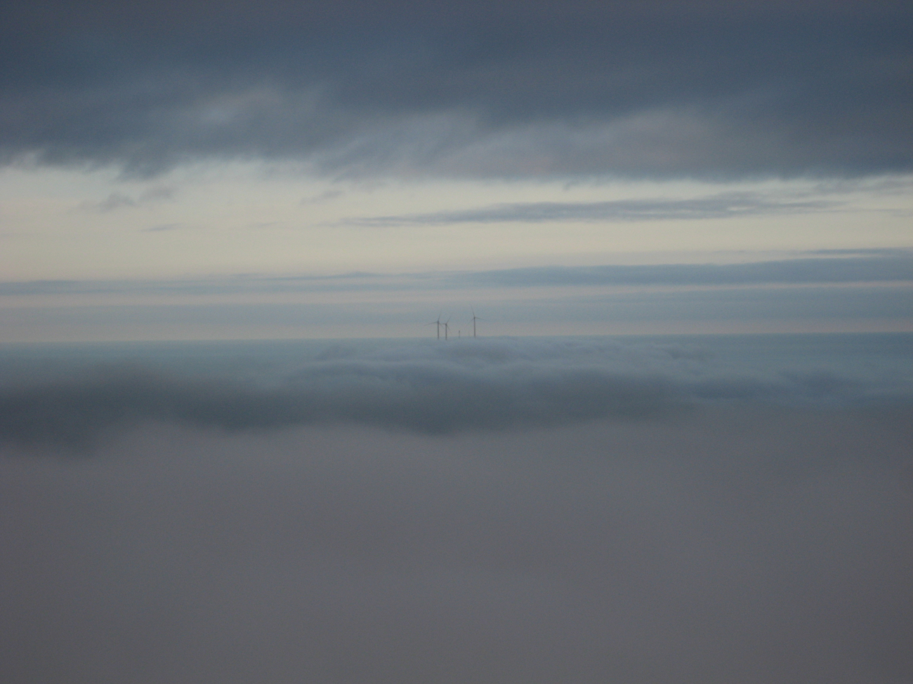 The windmills of Kodiak Island standing above the clouds
