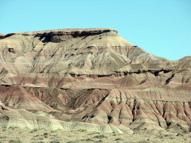 A mesa with red and grey sedimentary layers