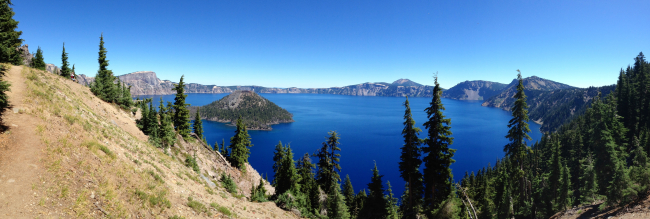 A panorama of Crater Lake with Wizard Island in the left center