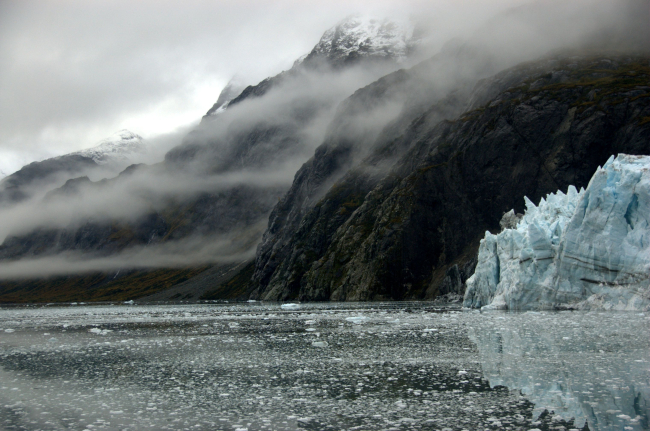 The incomparable scenery of Tarr Inlet - steep-sided fjord, wisps of clouds,a reflecting glacier
