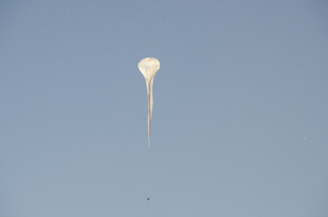 An ozonesonde balloon rises into a clear South Pole sky