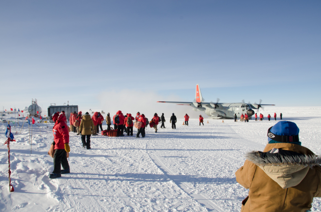 Scientists arriving at South Pole Station and disembarking from C-130 aircraft
