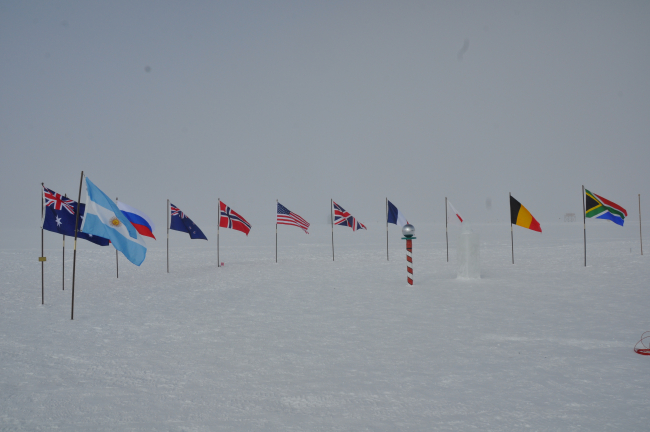 Ceremonial South Pole with flags of nations that have contributed to South Polar science