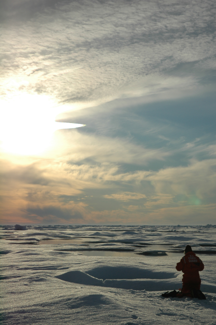 Scientist working on Arctic ice beneath the midnight sun