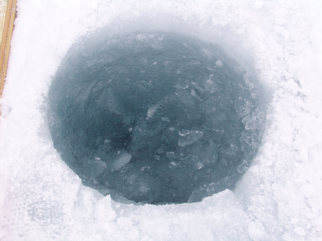 Hole cut through ice for SCUBA diving operations