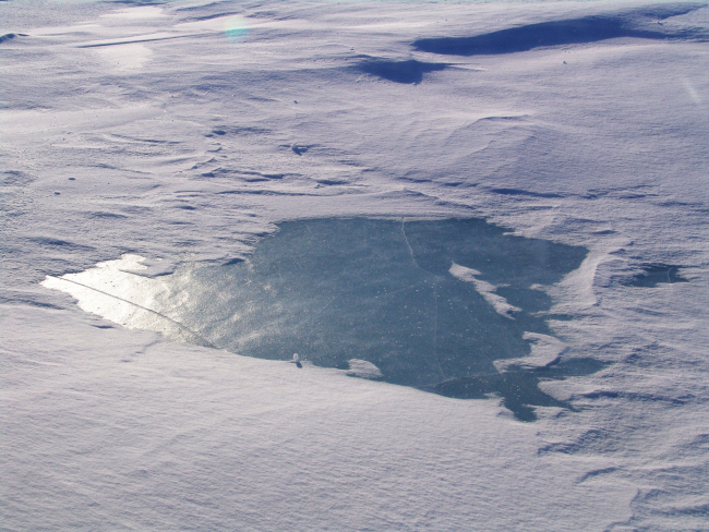 A large frozen over melt pond