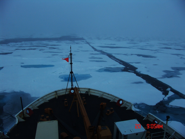 The bow of the CGC HEALY plowing through ice floes and melt pools